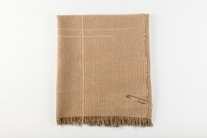 Textured brown blanket with frayed edges on a white background