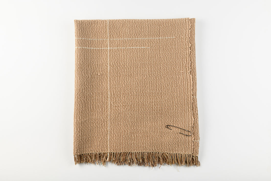 Textured brown blanket with frayed edges on a white background